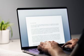 Stemp back view of person in home office writing cover letter