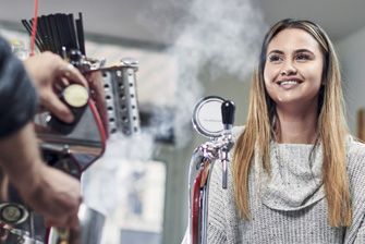 Stemp content worker smiles at her cafe job