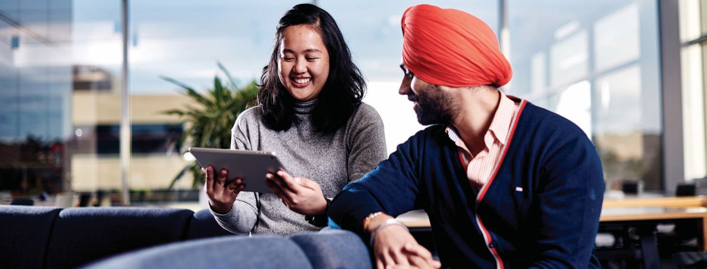 Campus couple looking at tablet