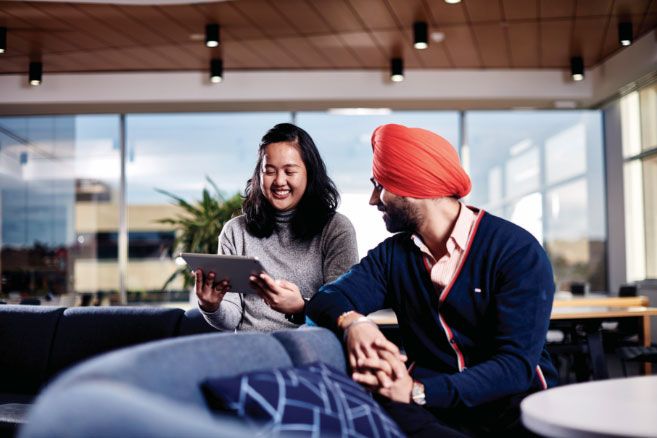 Campus couple looking at tablet device