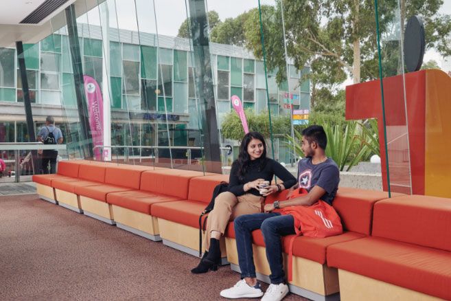 Campus couple talking and drinking coffee