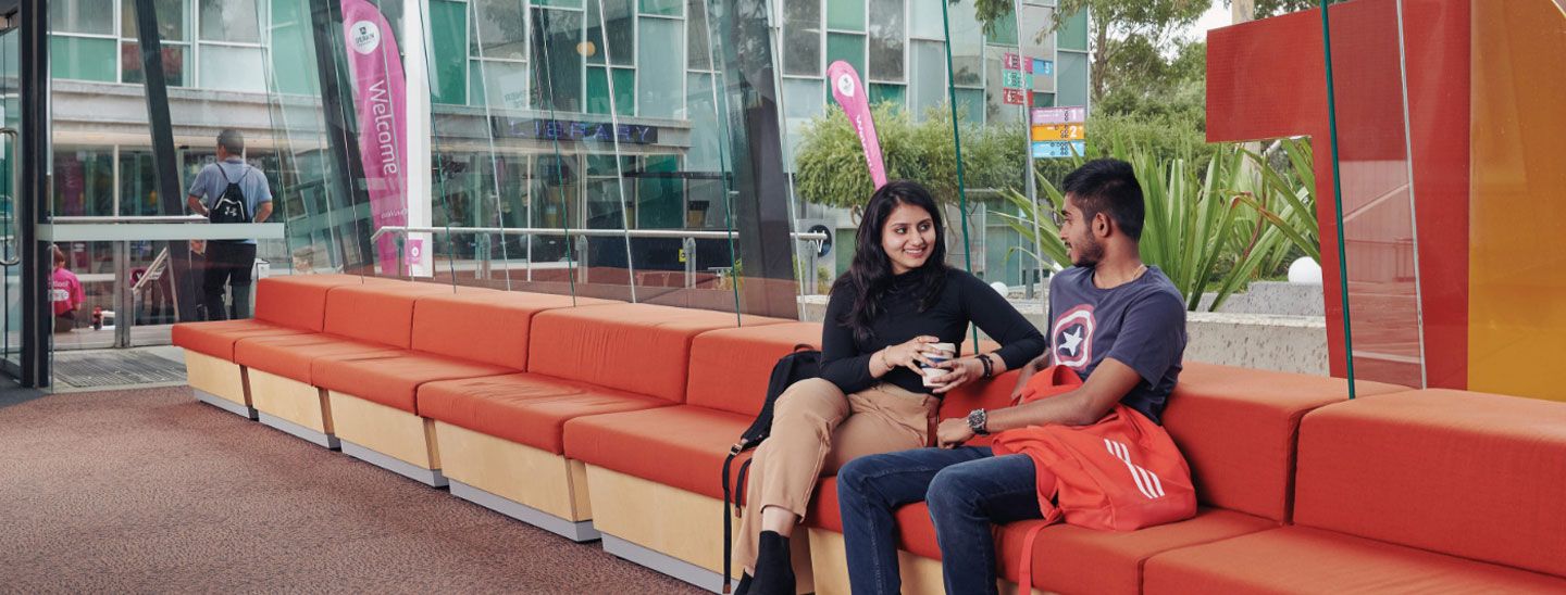 Campus couple talking and drinking coffee