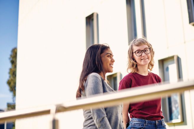 Campus couple walking next to railing