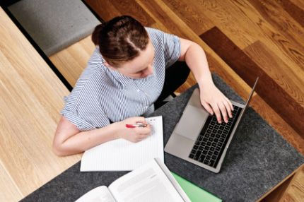 Campus female caucasian note taking from laptop