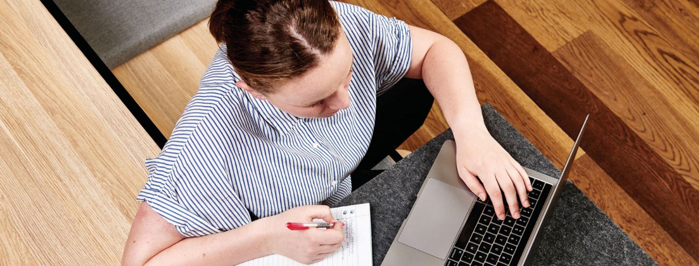 Campus female caucasian note taking from laptop