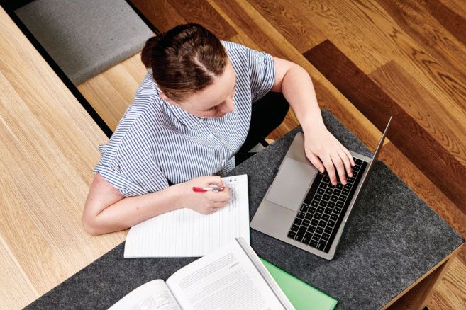 Campus female caucasian writing notes from laptop
