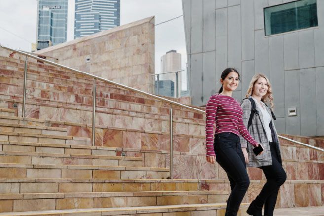 Campus female couple walking down stairs