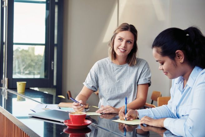 Campus female couple writing notes