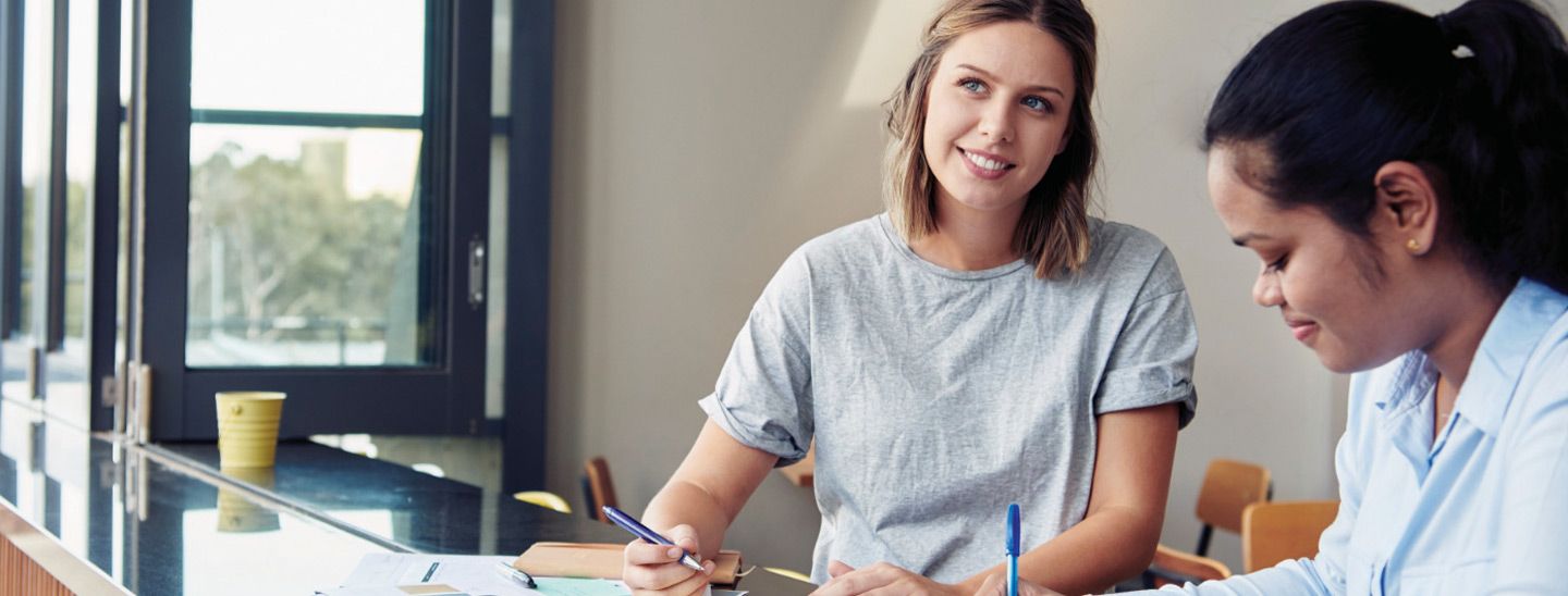 Campus female couple writing notes