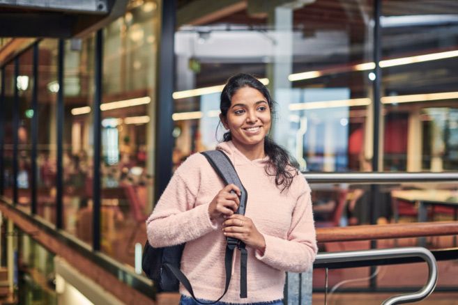 Campus female standing outside glass wall