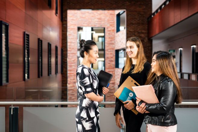 Campus group discussing and holding notepads