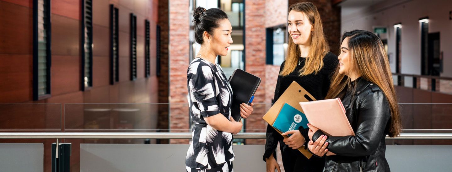Campus group discussing and holding notepads