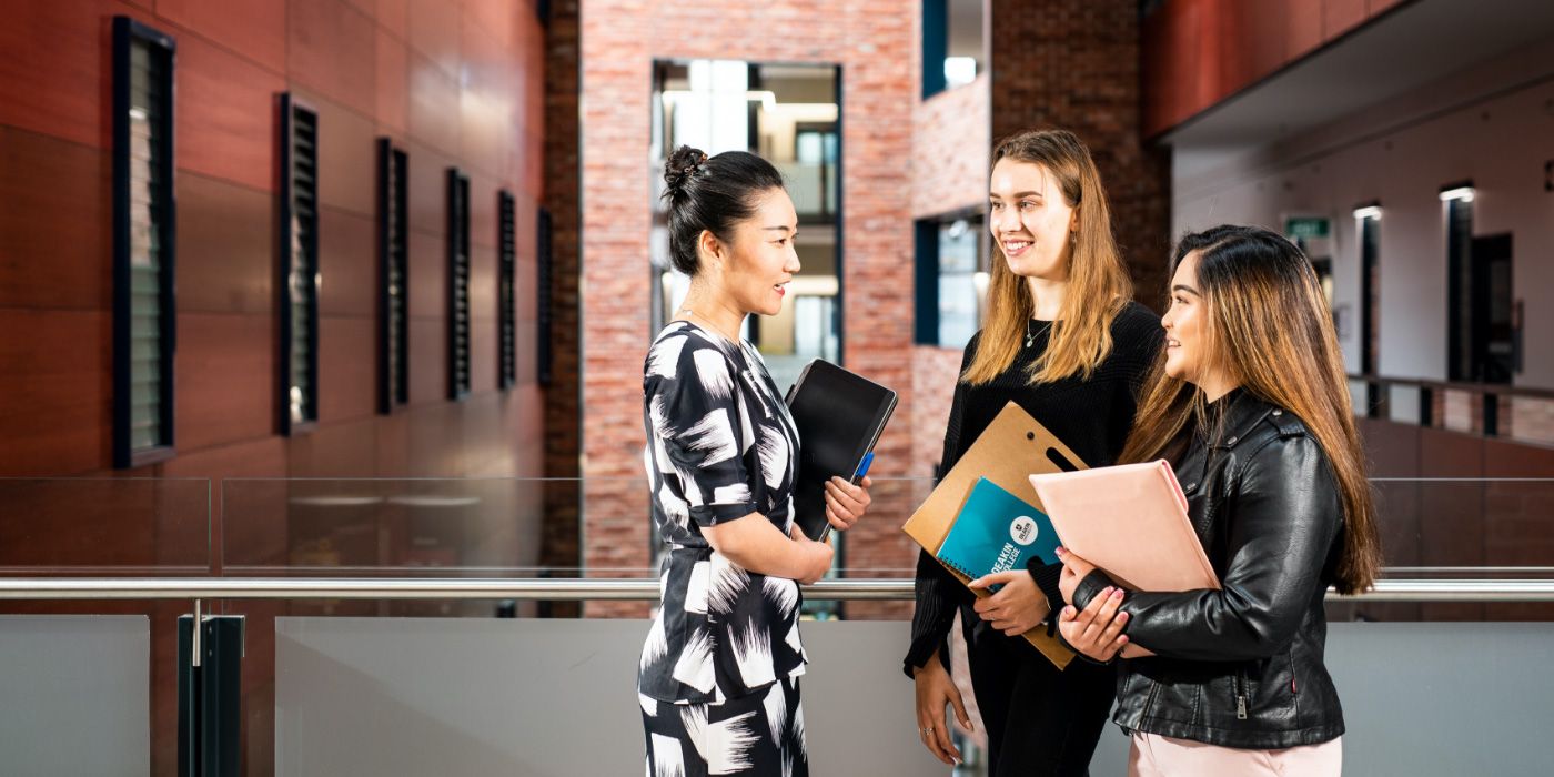 Campus group discussing and holding notepads
