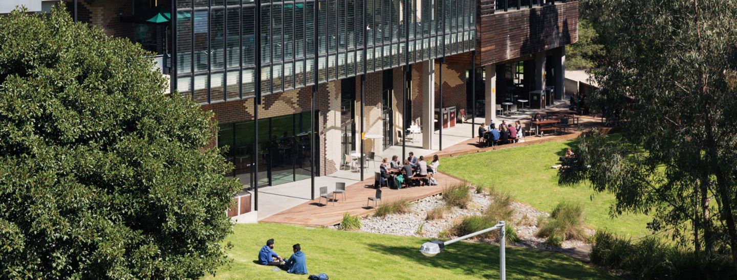 Campus group sitting outside building