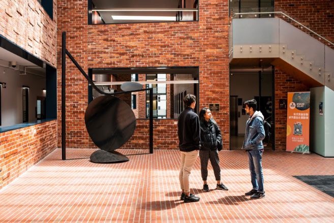 Campus group standing in front of brick building