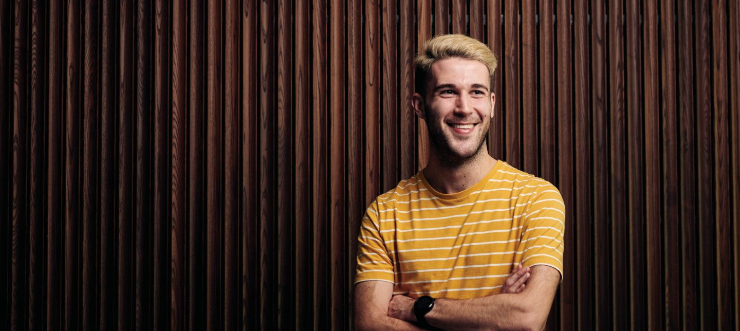 Male caucasian in front of wood panelled wall