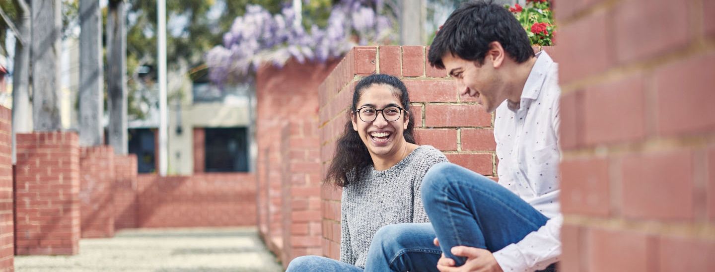 Female and male sitting and laughing