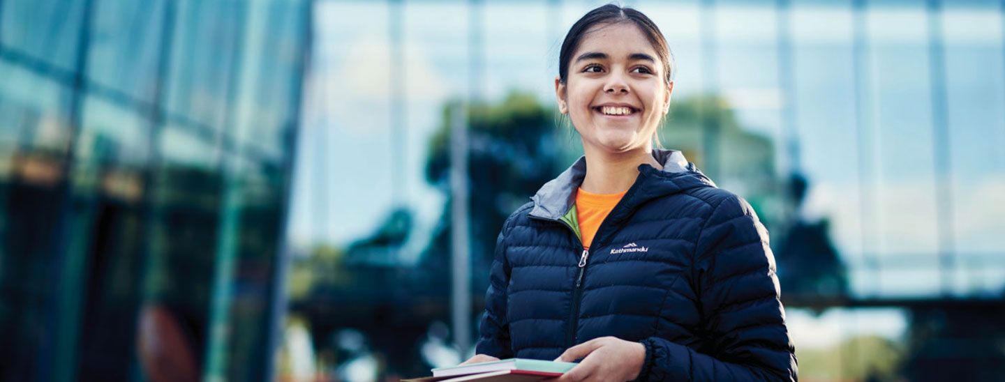 Female standing holding books