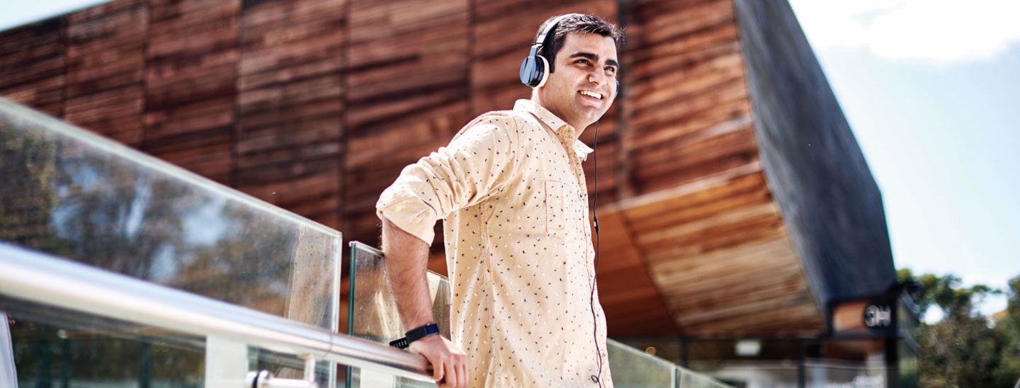 Male leaning on glass walkway
