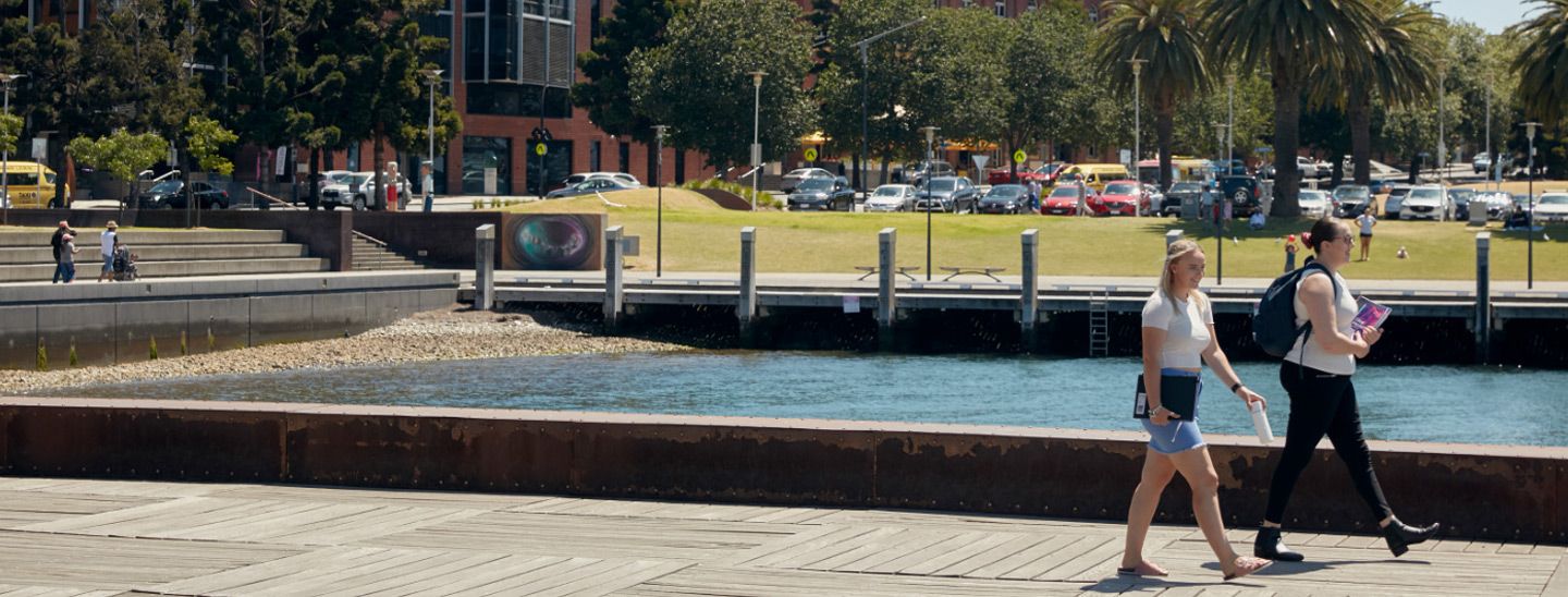 Off campus couple walking on jetty