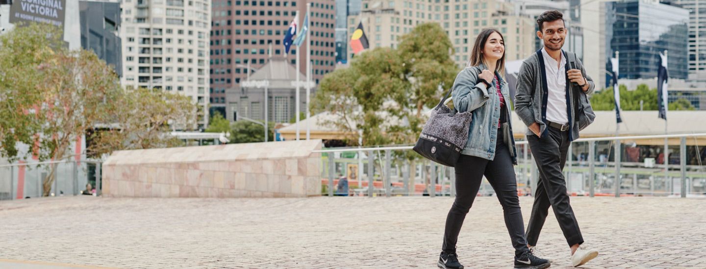 Off campus couple walking over bridge in city