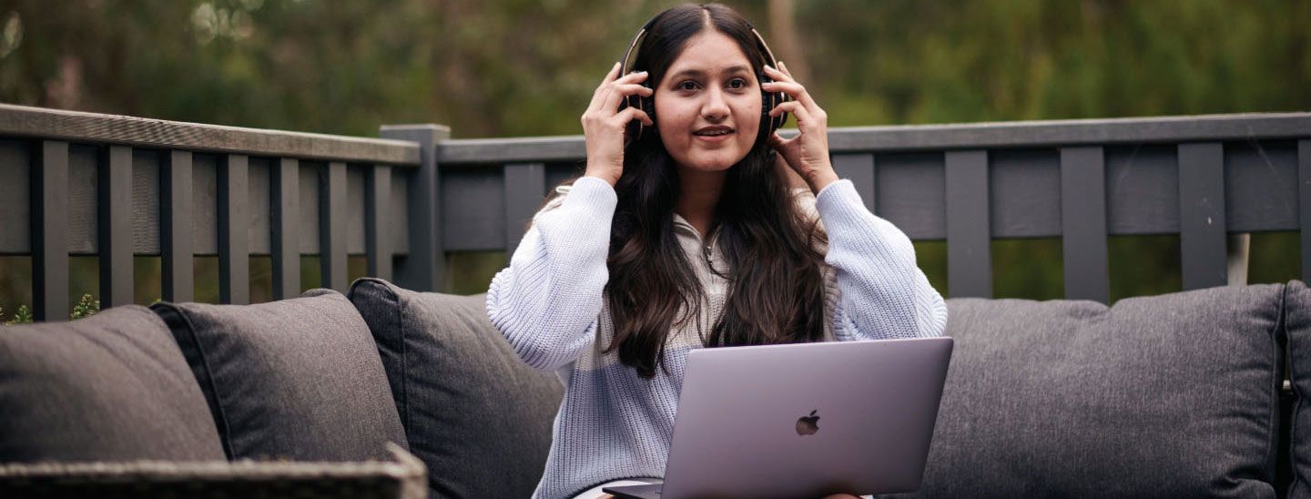 Off campus female with headphones and laptop