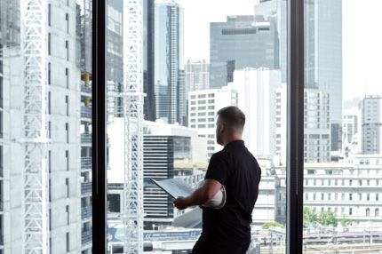 Off campus male caucasian checking engineering blueprints