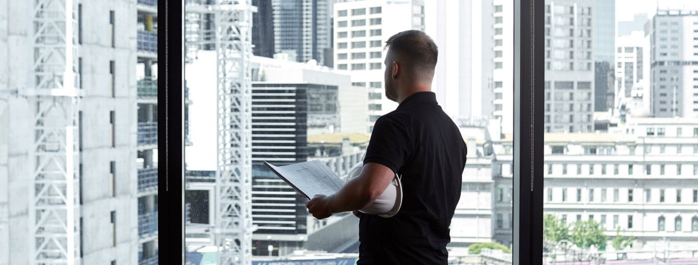 Off campus male caucasian checking engineering blueprints